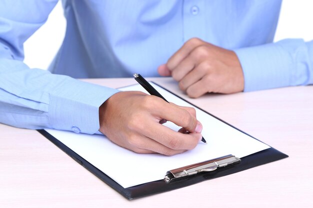 Homem de negócios que escreve no original no close up do escritório