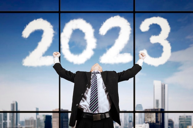 Homem de negócios que expressa o sucesso perto do número 2023