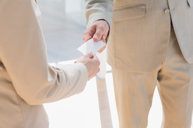 Homem de negócios que passa cartão branco para empresária