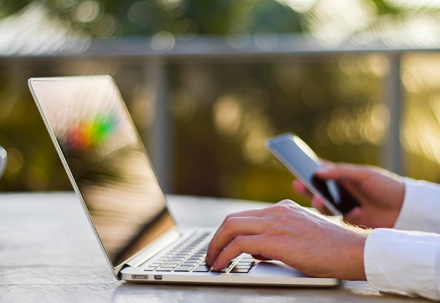 Homem de negócios que trabalha com portátil e telefone celular