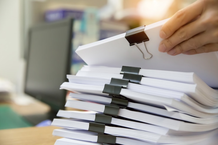Foto homem de negócios que trabalha no papel das pilhas para procurar a informação no escritório da mesa do trabalho.