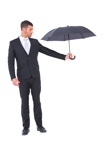 Homem de negócios segurando guarda-chuva preto ao lado dele