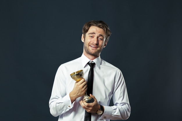 Homem de negócios, segurando o troféu da copa de ouro