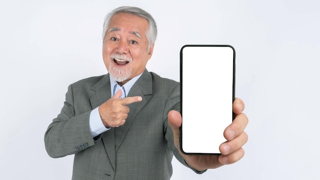 Homem de negócios sênior asiático com terno se sente feliz apontando o dedo para o grande telefone inteligente com tela em branco tela branca isolada no fundo branco tela vazia do telefone inteligente Mock Up Image