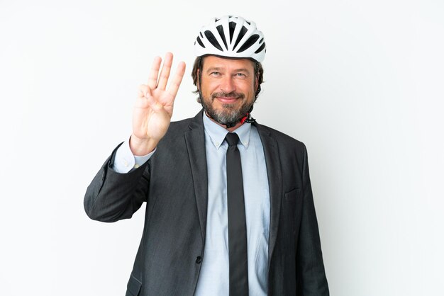 Homem de negócios sênior com um capacete de bicicleta isolado no fundo branco feliz e contando três com os dedos