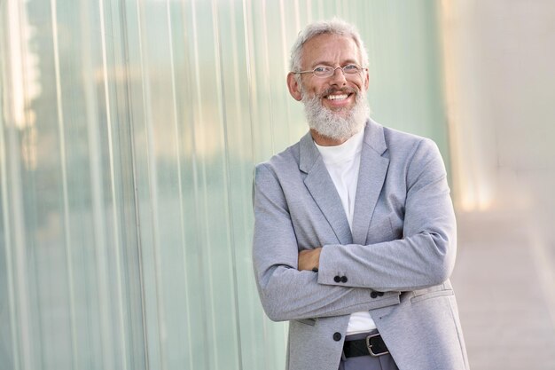 Homem de negócios sênior feliz confiante vestindo terno em pé retrato ao ar livre