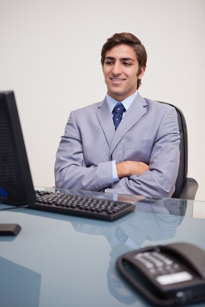 Homem de negócios sentado na frente do computador de mesa