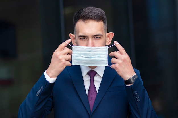 Homem de negócios sério com máscara médica no rosto