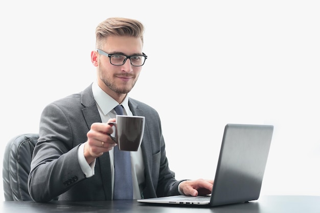 Homem de negócios sério com uma xícara de café sentado em seu deskphoto com espaço de cópia