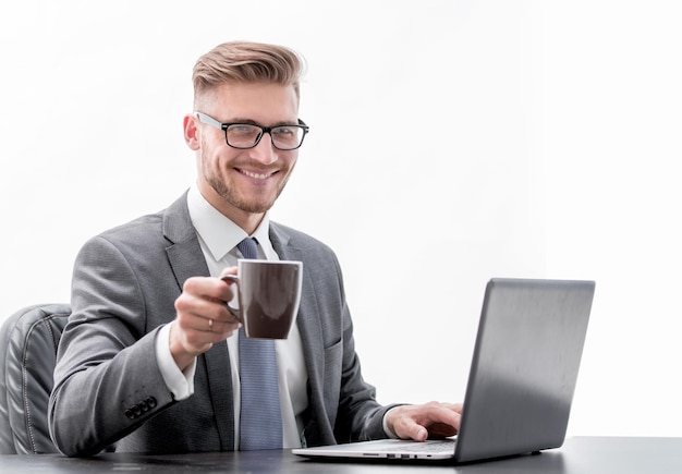 Homem de negócios sério com uma xícara de café sentado em sua mesa