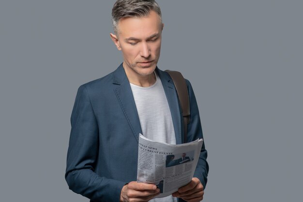 Foto homem de negócios sério olhando para o jornal