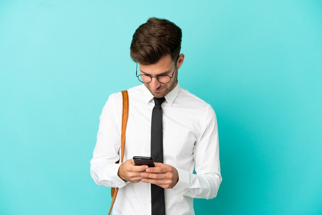 Homem de negócios sobre fundo isolado enviando uma mensagem com o celular