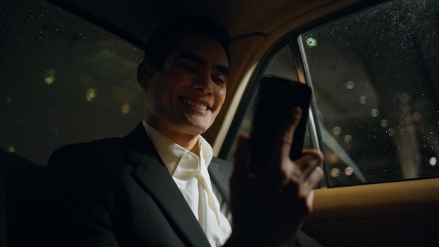 Foto homem de negócios sorridente a falar ao telefone no carro, empresário sorridente a ligar.