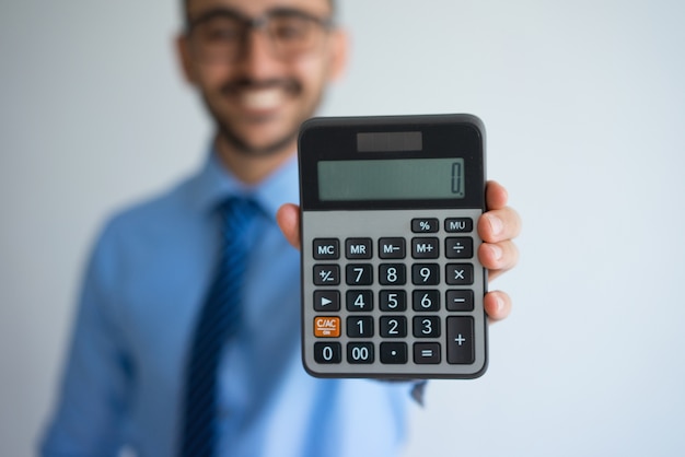 Homem de negócios sorrindo mostrando zero na calculadora