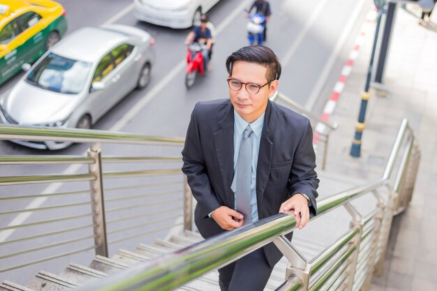 Homem de negócios, subindo as escadas na hora do rush para trabalhar.