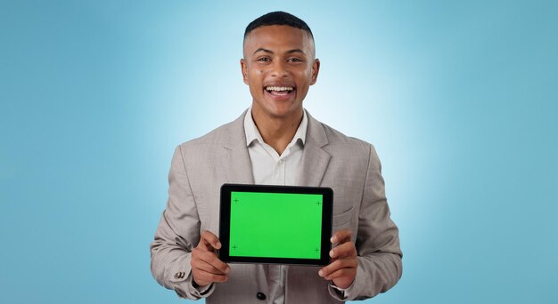 Homem de negócios tablet tela verde e publicidade para o espaço do site informações ou software de negociação em estúdio Retrato de comerciante com espaço de maquete digital e marcadores de rastreamento em um fundo azul