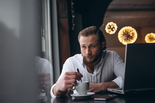 Homem de negócios trabalhando com laptop e bebendo café em um café