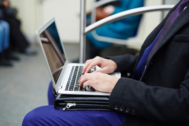 Homem de negócios trabalhando com laptop no metrô