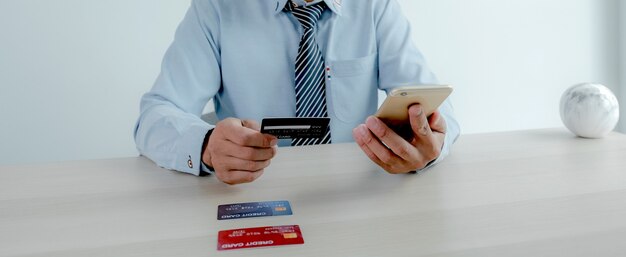 Foto homem de negócios usa cartão de crédito para compras online de casa com laptop, comércio eletrônico de pagamento.