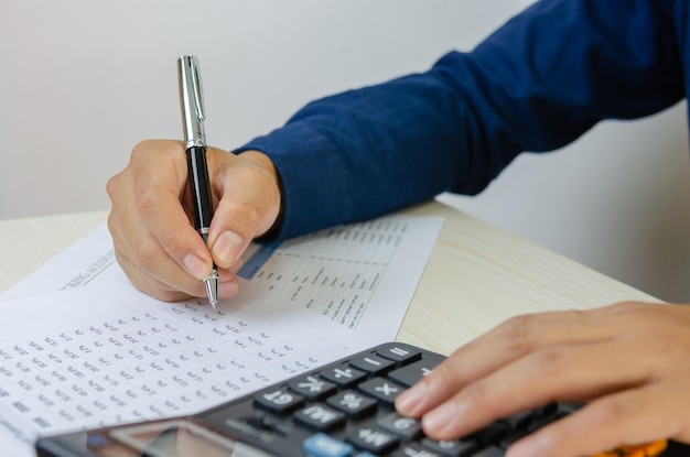 Homem de negócios usando a calculadora em uma mesa Economia fiscal de finanças empresariaisxConceitos de empréstimo e investimento
