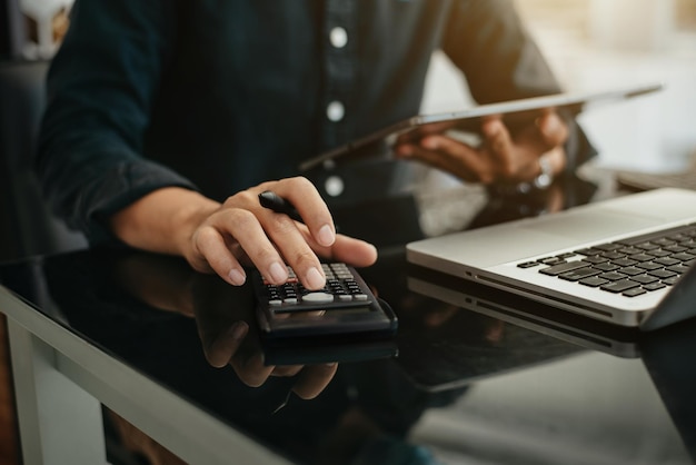 Homem de negócios usando calculadora com tablet e computador laptop Orçamento de contabilidade empresarial e papel de empréstimo em officex9