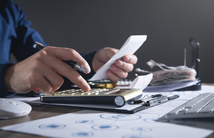 Foto homem de negócios usando calculadora e segurando contas. o negócio