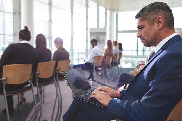 Foto homem de negócios usando laptop durante um seminário de negócios