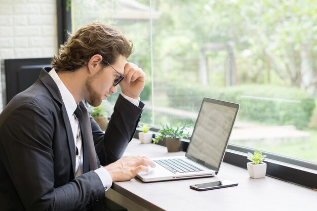 Foto homem de negócios usando laptop na mesa no escritório