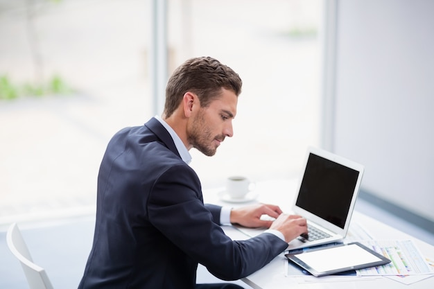 Homem de negócios usando o laptop na mesa