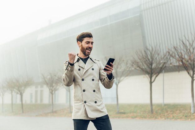 Homem de negócios usando smartphone enquanto caminhava