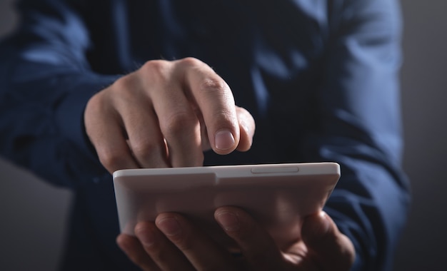 Homem de negócios usando tablet digital branco.