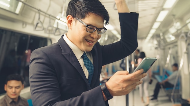 Homem de negócios usando telefone celular em trem público