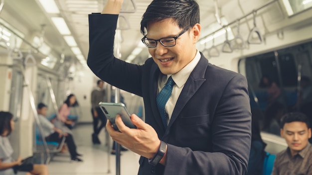 Homem de negócios usando telefone celular em trem público