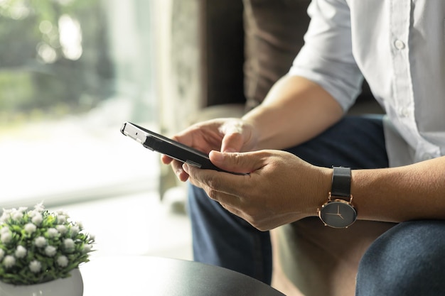 Homem de negócios usando telefone celular para comunicar homem de negócios sentado no sofá Sala de estar em casa