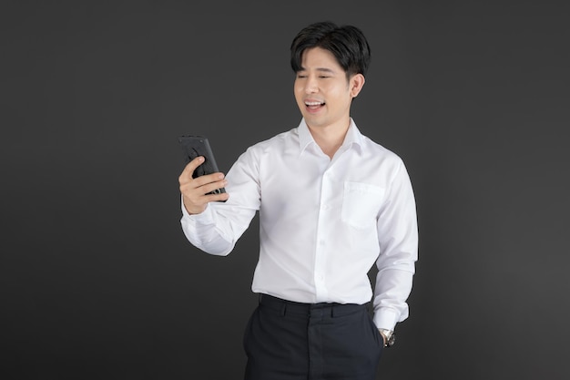Homem de negócios, vestindo camisa branca, segurando o celular