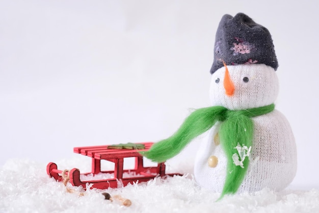 Foto homem de neve feito sozinho com trenó vermelho como decoração de natal