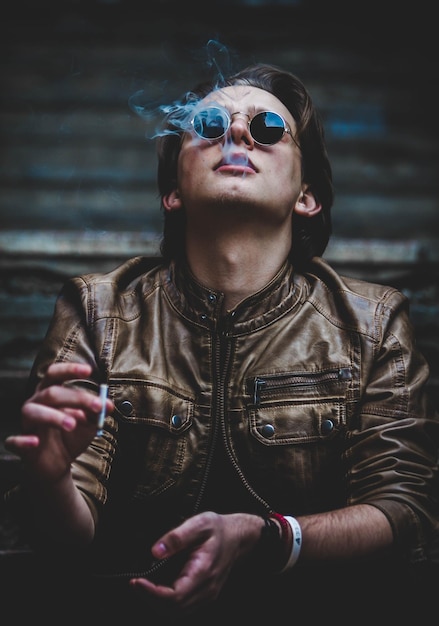Homem de óculos de sol a fumar um cigarro