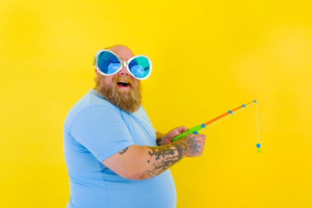 Foto homem de óculos de sol de pé contra fundo amarelo