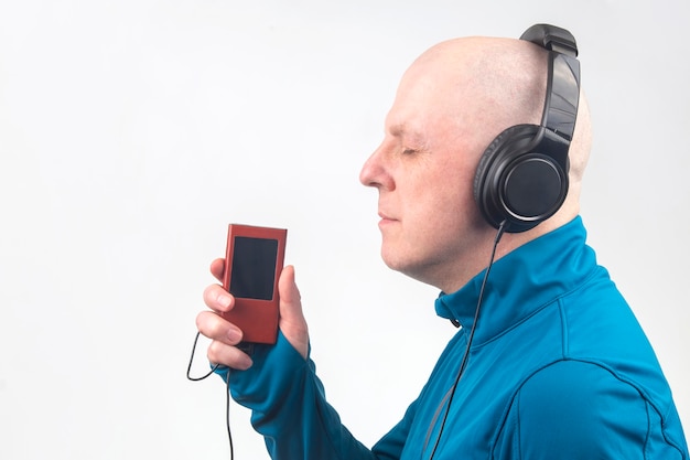 Homem de olhos fechados ouve música com fones de ouvido