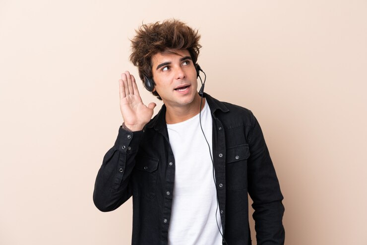 Foto homem de operador de telemarketing trabalhando com um fone de ouvido sobre parede isolada, ouvindo algo