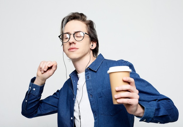 Homem de pé com café para viagem feliz cara bonito despreocupado em óculos