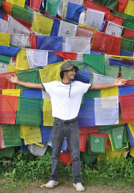 Foto homem de pé contra bandeiras de oração