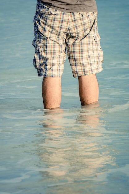 Homem de pé na água do mar