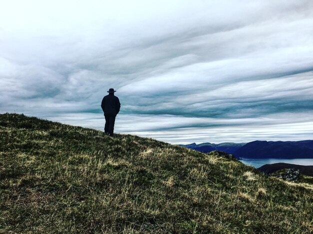 Homem de pé na montanha contra o céu