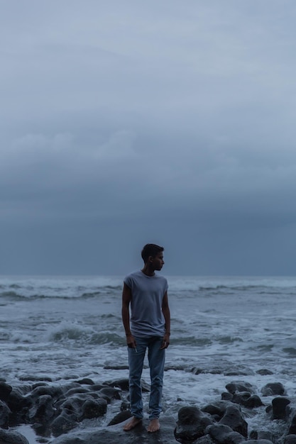 Homem de pé na praia contra o céu