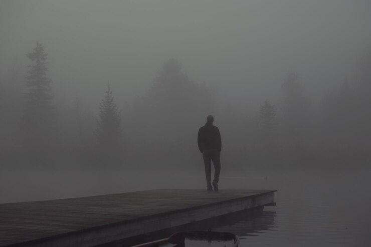 Foto homem de pé no cais sobre o lago contra o céu