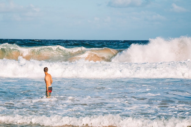 Homem de pé no canal da ilha de Kauai, Havaí