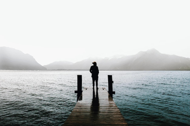 Foto homem de pé no lago contra o céu claro