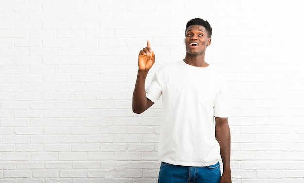 Homem de pele escura com a intenção de perceber a solução enquanto levanta um dedo