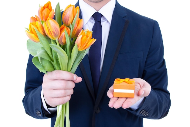 Homem de proposta segurando caixa de presente com aliança de casamento e flores isoladas em branco